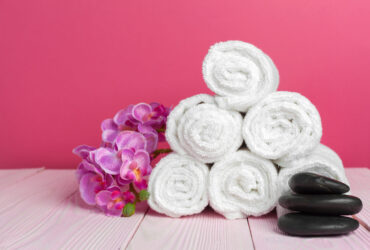 clean soft towels with flower on wooden table. creative photo.